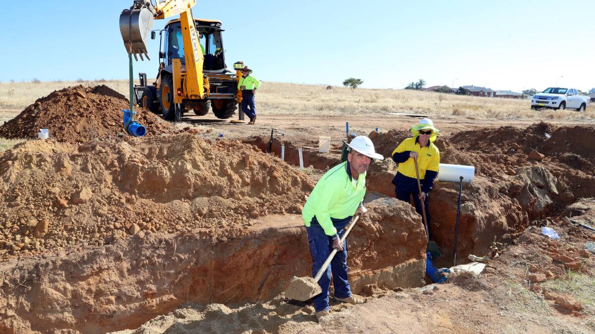 Peter Looney and Paul Gibbons dig a ditch to lay water pipes at land slated for a shopping centre at Estella. Picture: Les Smith
