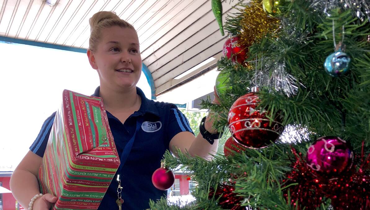 Kelsey Leaver from Sportsmans Warehouse hangs baubles on the tree.