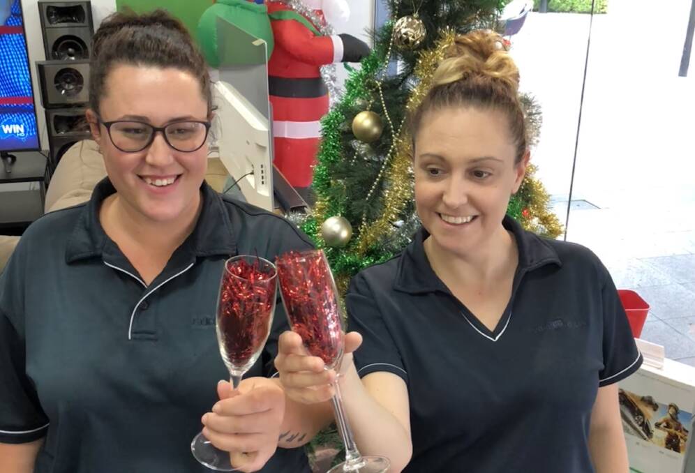 CHEERS: Jess Barrass and Kelly Nicholls from Radio Rentals celebrate completing the Christmas window display of the Baylis Street store.