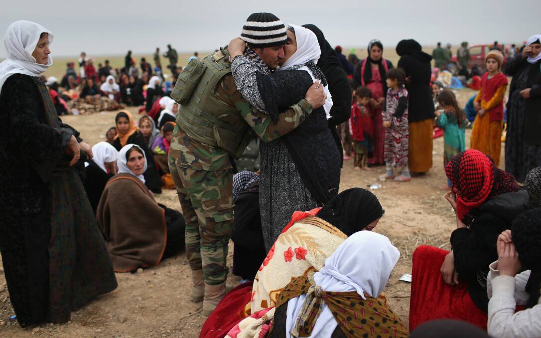 A Yazidi Peshmerga fighter embraces his mother after she and others fled their frontline village to a Kurdish-controlled area. Peshmerga forces carefully screened displaced Iraqis as they arrived, fearing enemy infiltrators and suicide bombers. Kurdish forces, with the aid of massive US-led coalition airstrikes, liberated Sinjar from ISIS extremists, known in Arabic as Daesh, moving the frontline south. Picture: John Moore/Getty Images.