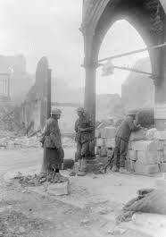 Three members of the 2nd Division standing outside the Mairie (Town Hall) of Bapaume. Picture: Australian War Memorial