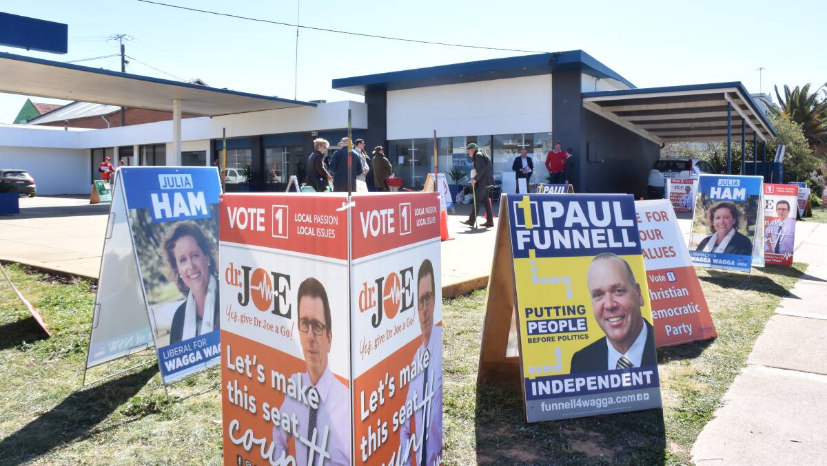 Volunteers hand out how-to-vote cards outside the Edward Street pre-poll centre to early voters in the 2018 Wagga byelection. Picture: Rex Martinich 