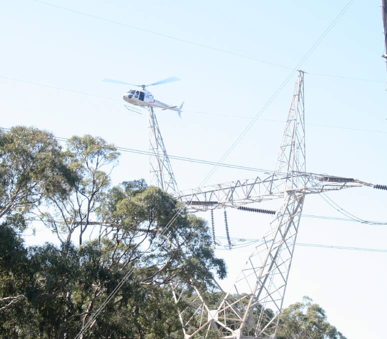A TransGrid helicopter checks for faults on a high-voltage transmission line. The network operator has cleared a stage of approval for a $1 billion new line from Wagga to South Australia.