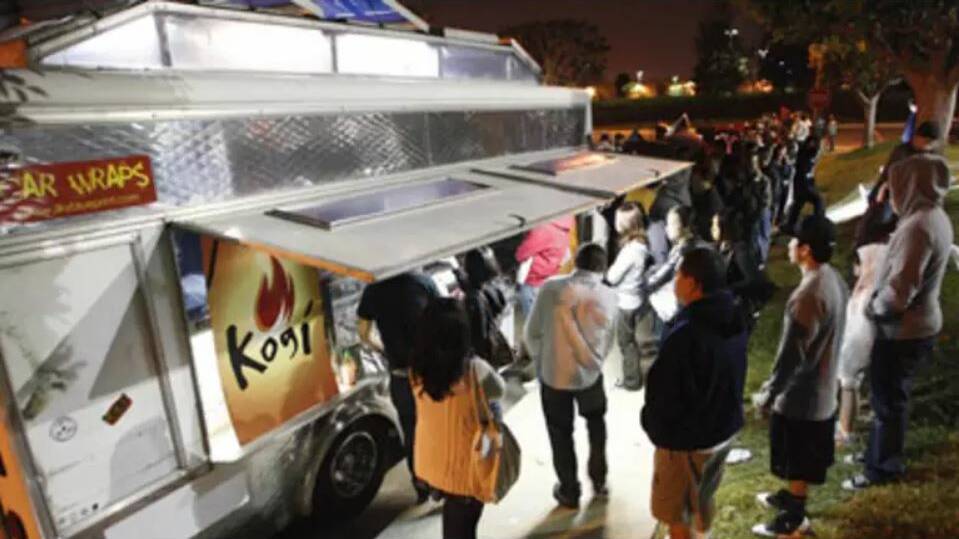 People wait for food as others line up to place their orders at Kogi, a Korean BBQ-inspired taco truck, in Torrance, California. Picture: Reuters