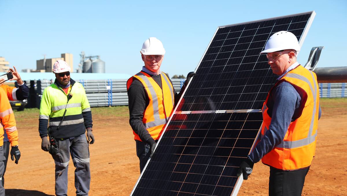 The first panel is ceremonially installed at Bomen's new solar farm in August. The NSW government is now looking to establish a new zone in South West NSW to encourage further renewable energy investment.