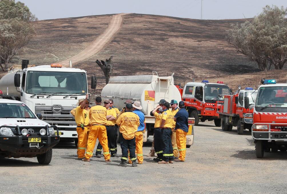 REBUILD: Firefighters meet to discuss tactics beside the Snowy Mountains Highway heading to Adelong during the Dunns Road bushfire this month. Snowy Valleys Council has approved a bushfire recovery plan. 