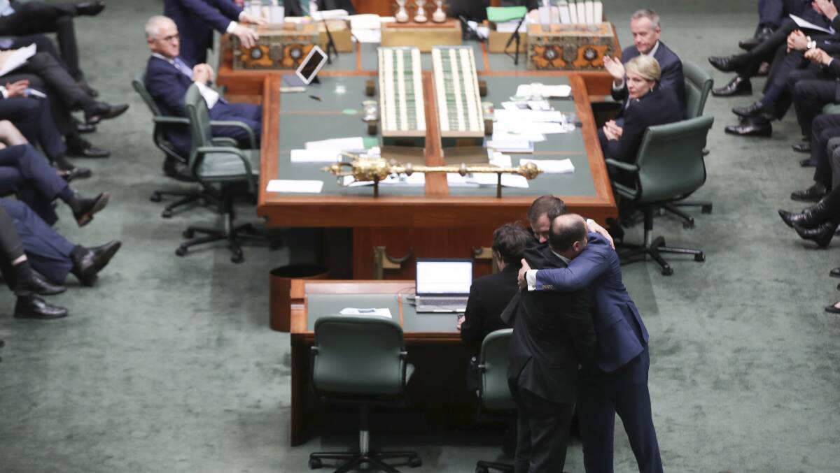 Minister for Environment and Energy Josh Frydenberg embraces Labor MP Ed Husic on Wednesday after he spoke in the House of Representatives in response to Senator Fraser Anning's first speech in the Senate. Picture: Alex Ellinghausen