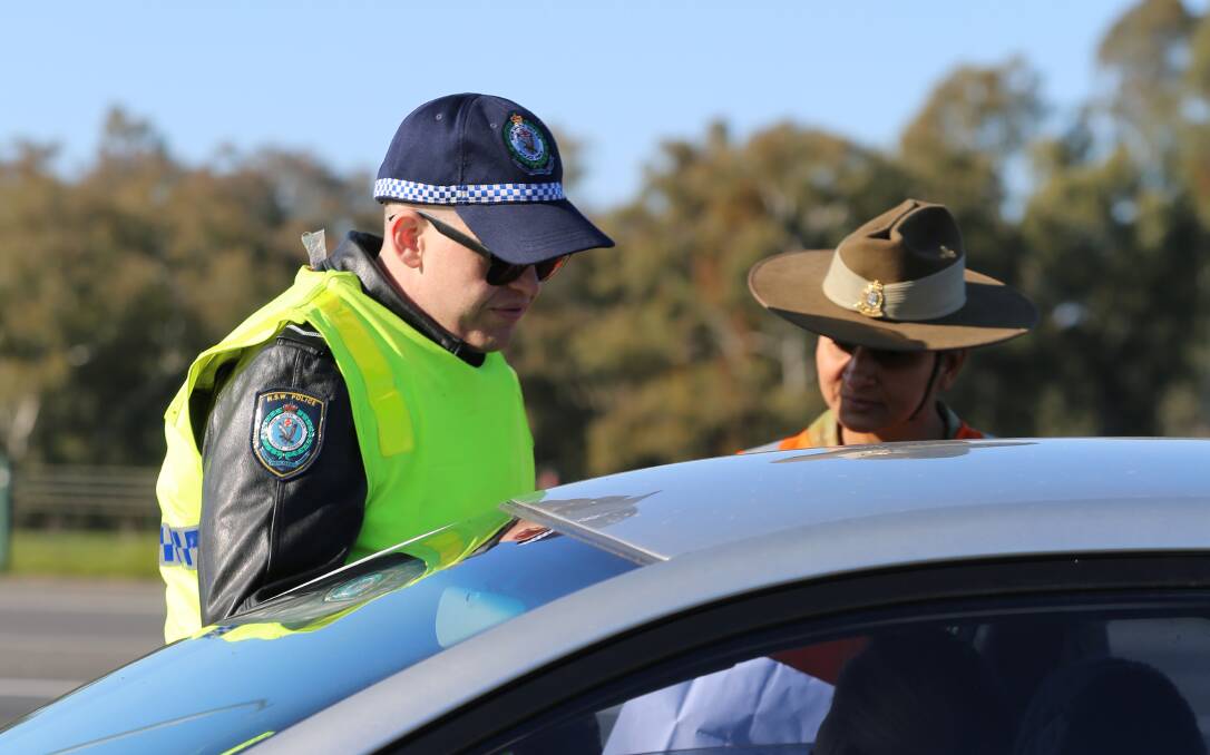 Soldiers and police check cars on their way through the border cross at Albury. Picture: NSW Police