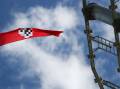 NOW BANNED: A Nazi flag is seen flying from the top of a light tower at Robertson Oval in February 2020. The offensive act partially inspired a new ban on displaying Nazi symbols.