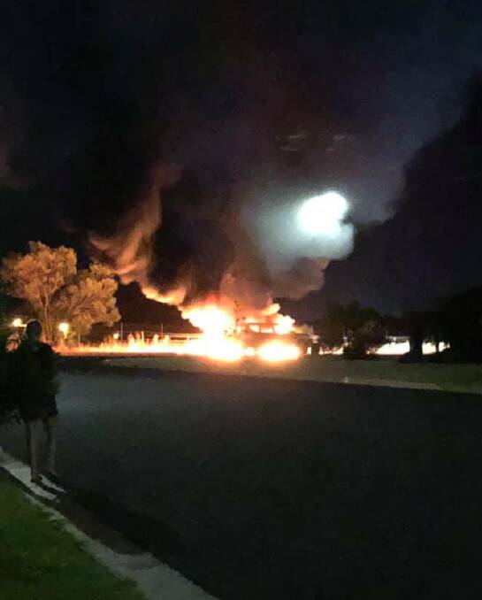 A car burns on the rail reserve in Glenfield Park. Picture: Nicole Bourke