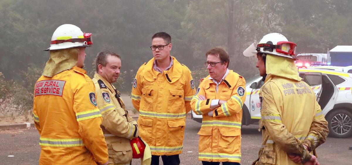 Nationals MP Wes Fang and Wagga independent MP Joe McGirr speak with firefighters at Batlow's old hospital earlier this month. 
