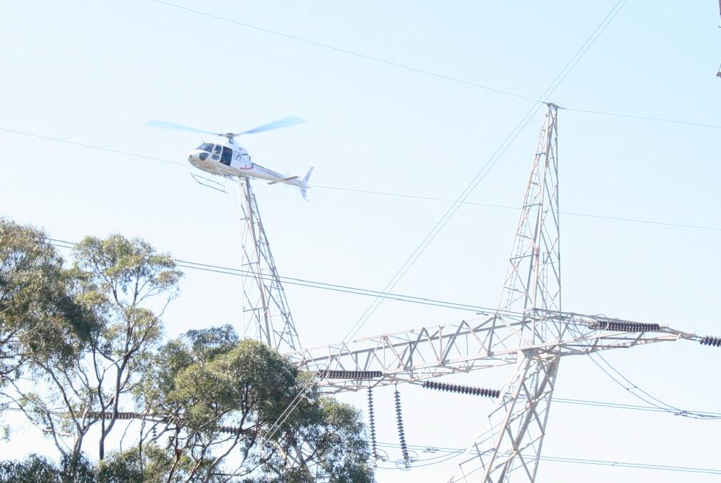ROUTINE: A TransGrid helicopter checks high voltage power lines around Wagga in 2018 for bushfire risks and maintenance issues. Picture: Contributed 