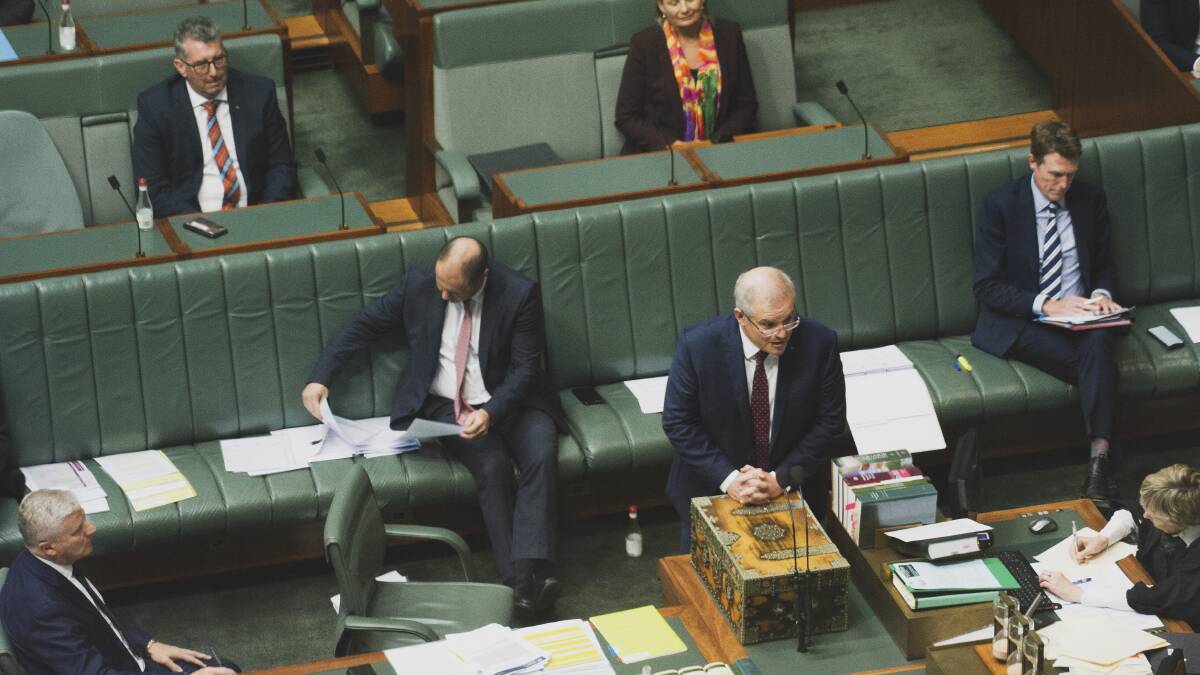 Riverina MP Michael McCormack (left) and Prime Minister Scott Morrison practise social distancing during question time at Parliament House on Monday. Picture: Dion Georgopoulos.