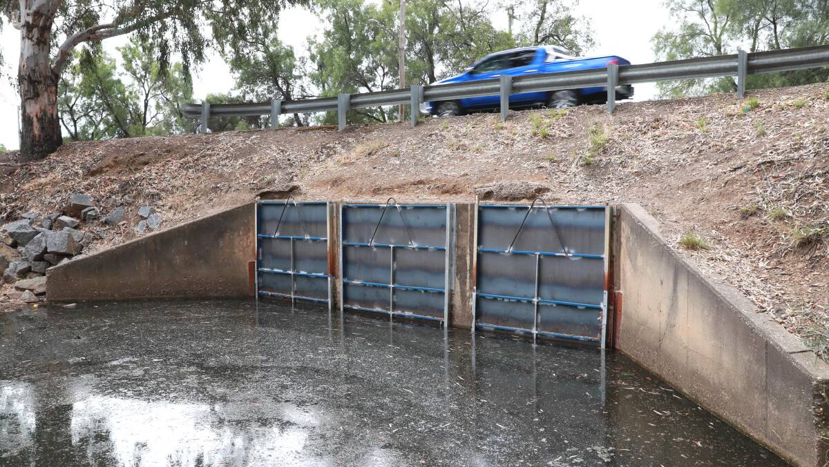 SHUTTERED: Steel gates across Tatton Drain that Wagga City Council said were illegally placed over Lake Albert Road culverts in O'Halloran Park sometime before Wednesday in an attempt to raise water levels in Lake Albert. Picture: Les Smith