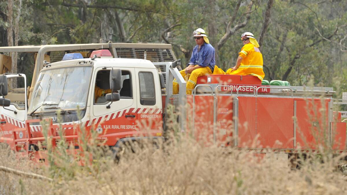 Firefighters take a break during back-burning operations in the aftermath of bushfire at Carabost in 2014.
