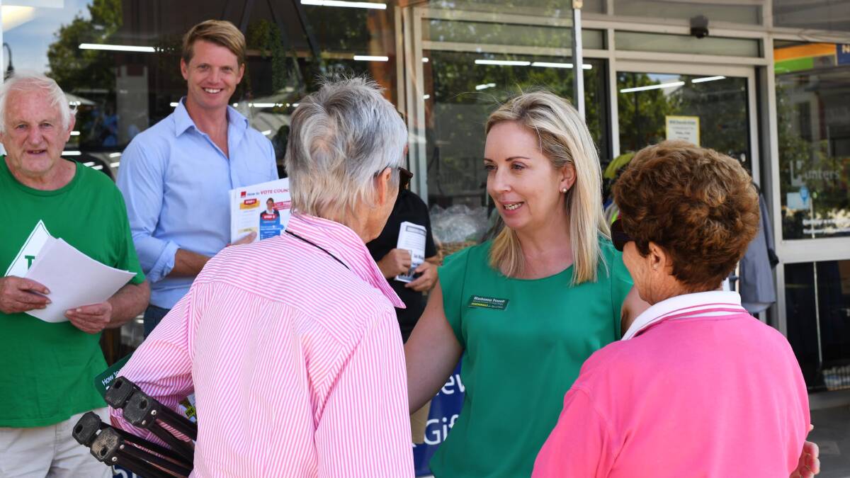 Wagga's major party candidates Dan Hayes, for Labor, and Mackenna Powell, for the Nationals, meet with voters outside the pre-polling centre.