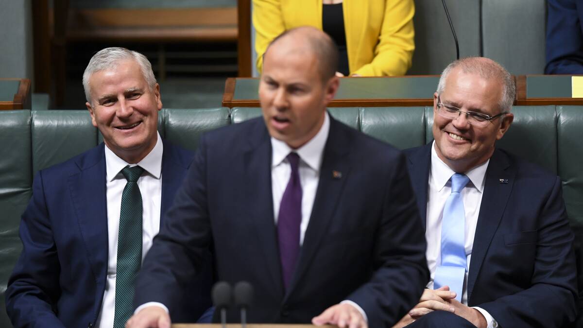 Deputy Prime Minister Michael McCormack (left) and Prime Minister Scott Morrison (right) and react as Treasurer Josh Frydenberg speaks at the dispatch box during the delivery of the 2019-20 Budget in Parliament on Tuesday. Picture: AAP/Lukas Coch