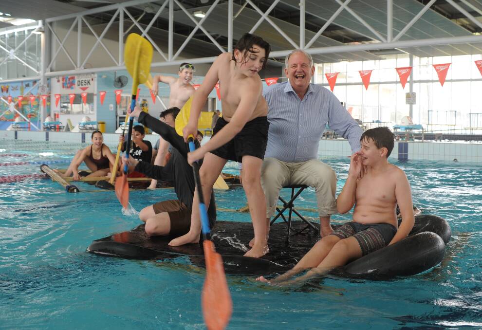 STAYING AFLOAT: Bidgee School students taking Wagga Mayor Greg Conkey on one of their specially built rafts across a swimming pool at Oasis Centre. Picture: Toby Vue