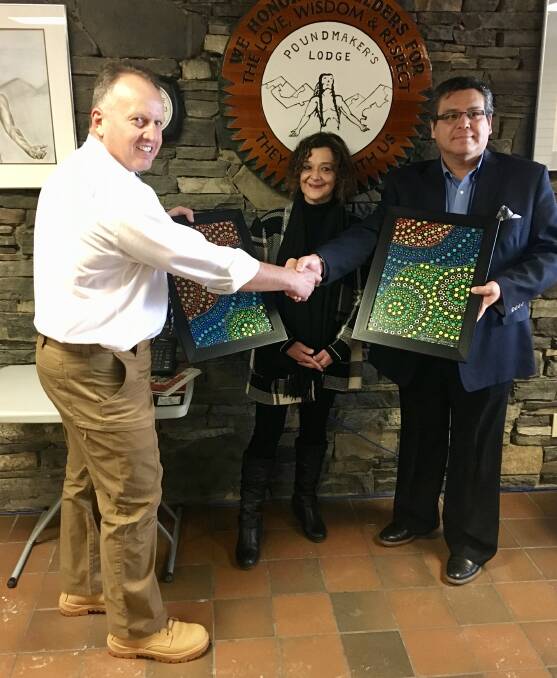 Detective Sergeant Phil Malligan (left) presents two Aboriginal paintings to the Canada's Indigenous Affairs members. Picture: Supplied