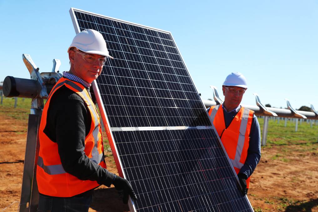 POWERING ON: Rick Francis and Doug McTaggart from Spark Infrastructure install the first solar panel at their site in Bomen. Picture: Emma Hillier
