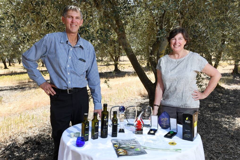 PASSION: W2 Olives' owners Geoff Treloar and Jenny Masters with their prize-winning product at their olive grove in Euberta after securing multiple trophies at the 2019 Australian Olive Association's conference last Friday.