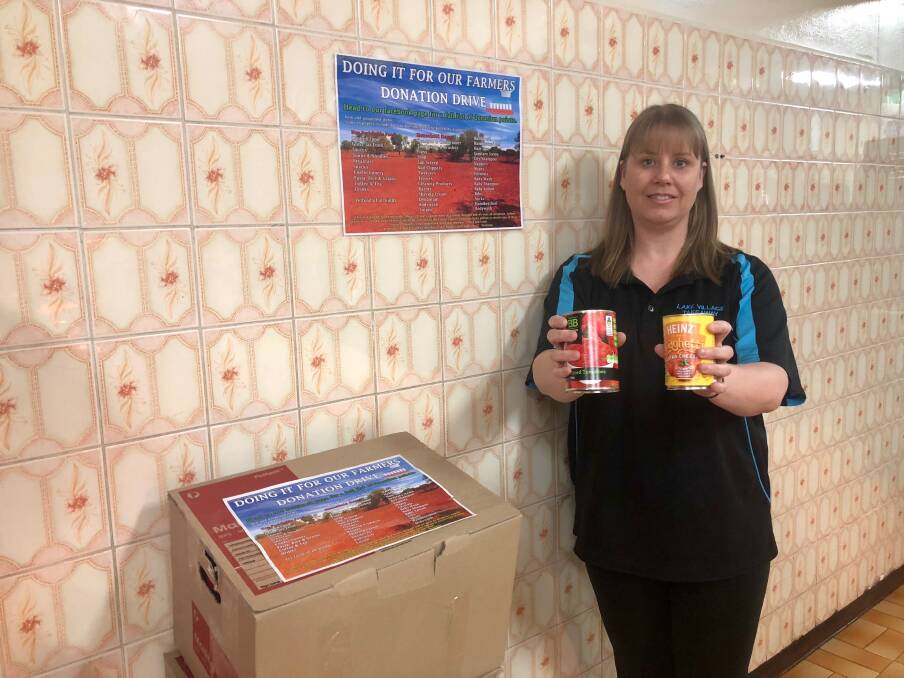 HELPING OUT: Kelly Roberts, owner of Village Lake Takeaway at Lake Albert, stands at the store's 'Wall of Donation' where residents may donate items for transport to farmers across the region. Picture: Toby Vue