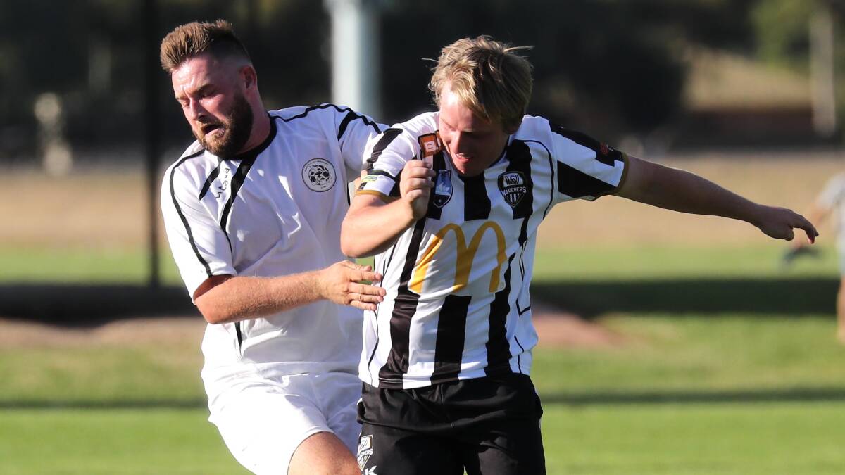 GRAPPLE: Hustville City defender Jordan Young wrangles with Wagga City Wanderers midfielder Duncan Cameron during their NSW State League clash on Saturday. 