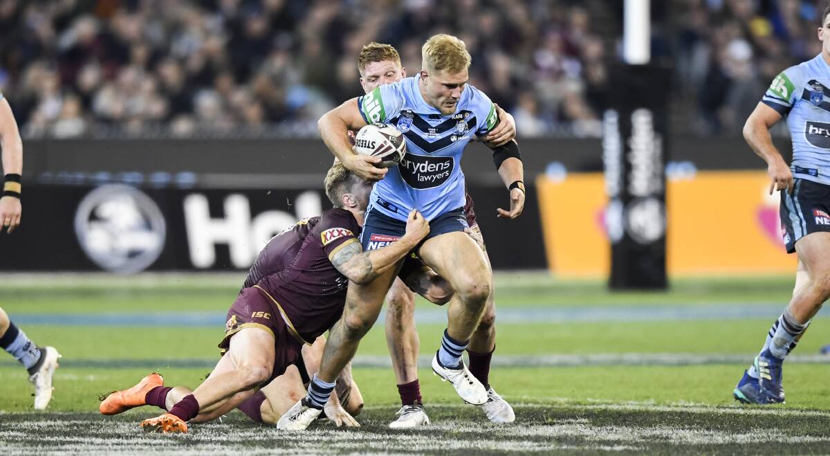 POWERHOUSE: Former Cootamundra junior Jack de Belin drives through the tackle of Maroons forward Dylan Napa during the Blues' series-clinching win at ANZ Stadium.