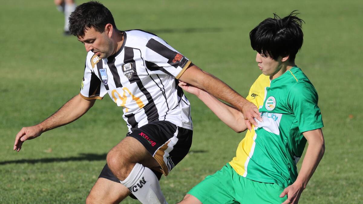 FORMER GLORY: Holt (left) sees off Bankstown FC's Toshihisa Saikawa during a 2018 clash. Picture: Les Smith
