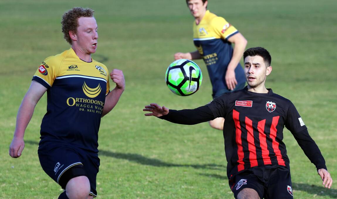 EYES ON THE PRIZE: Junee defender Ben Cook sets a collision course with Leeton striker Anthony Trifogli during their Pascoe Cup clash on Sunday. Picture: Les Smith