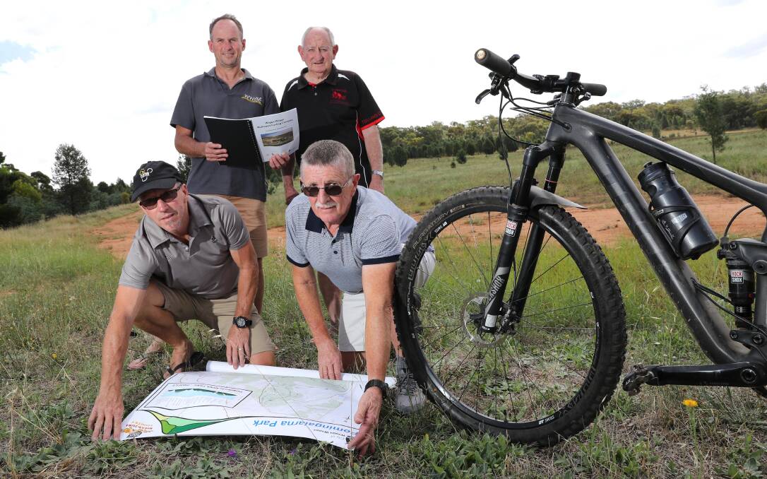 PEDAL POWER: members of Wagga's cycling community pose with plans for the Pomingalarna Park developments. 