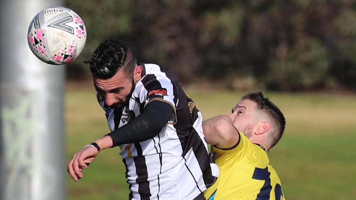 NEW LOOK: Fred Gardner (left) soars above South Coast Flame defender Grant Wilson during his Wagga City Wanderers debut at Gissing Oval last weekend. Picture: Les Smith