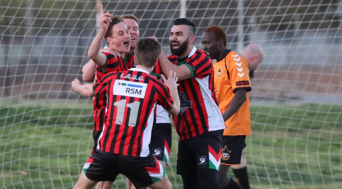 EUPHORIA: Nick Anderson (left) is swamped by Lake Albert team mates Duncan Brodie, Ben Matthews and Henri Gardner after scoring a vital goal in extra time. Picture: Les Smith