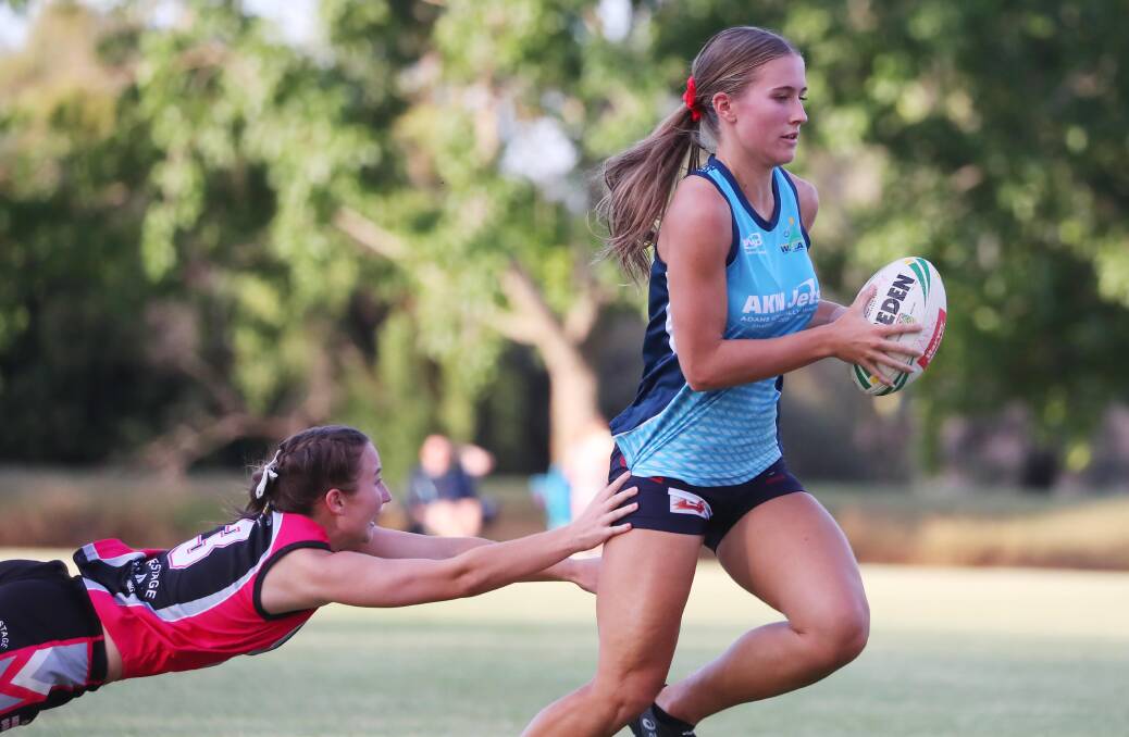 LUNGE: Young Guns' Lucy Anderson dives to her right to make a touch on AKW Jets' Rhiannon Podmore during the women's premier grade grand final at Jubilee Park on Tuesday night. Picture: Emma Hillier