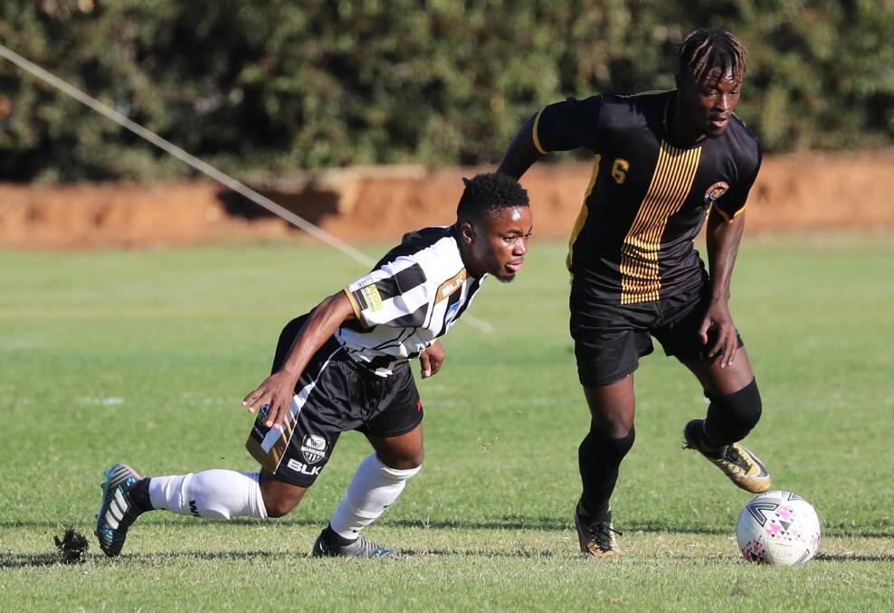 DAVID AND GOLIATH: Tinotenda Kunesu (Wagga City) and Swaray Kamara (Balmain) set their sights on the ball during their most recent State League encounter back in May. Picture: Les Smith