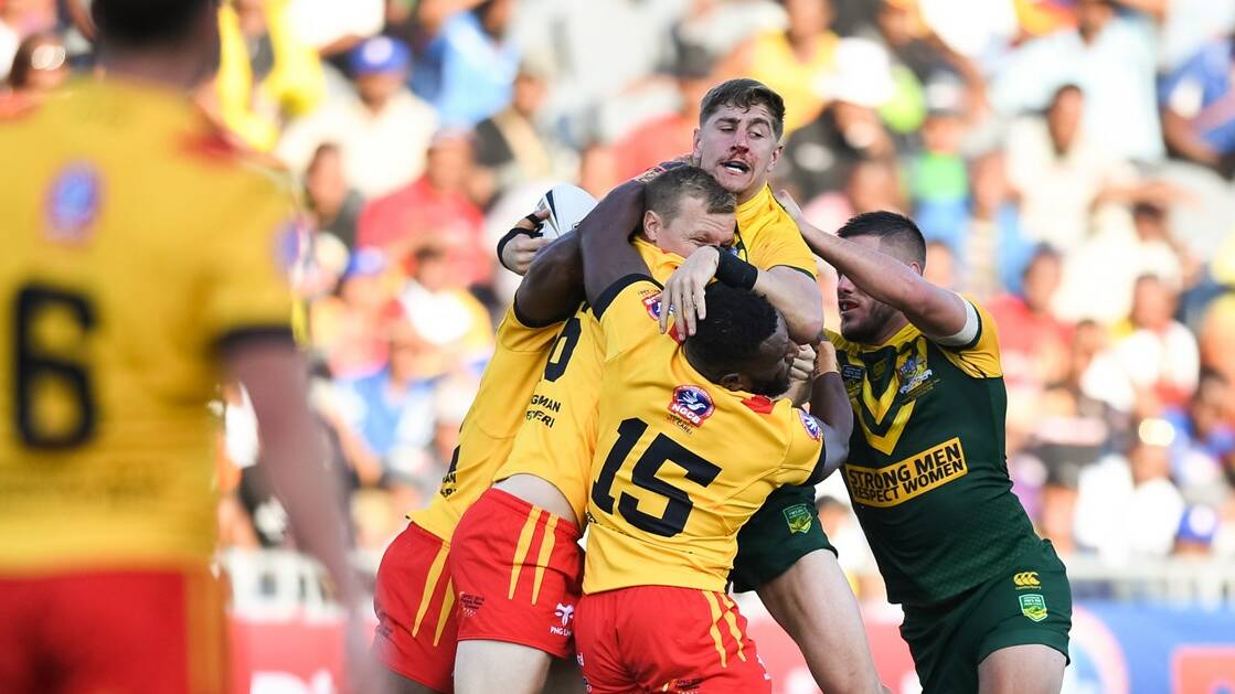 WRAPPED UP: Riverina teenager Zac Lomax takes a tackle during the clash between the Prime Minister's XIII and Papua New Guinea. Picture: National Rugby League. 