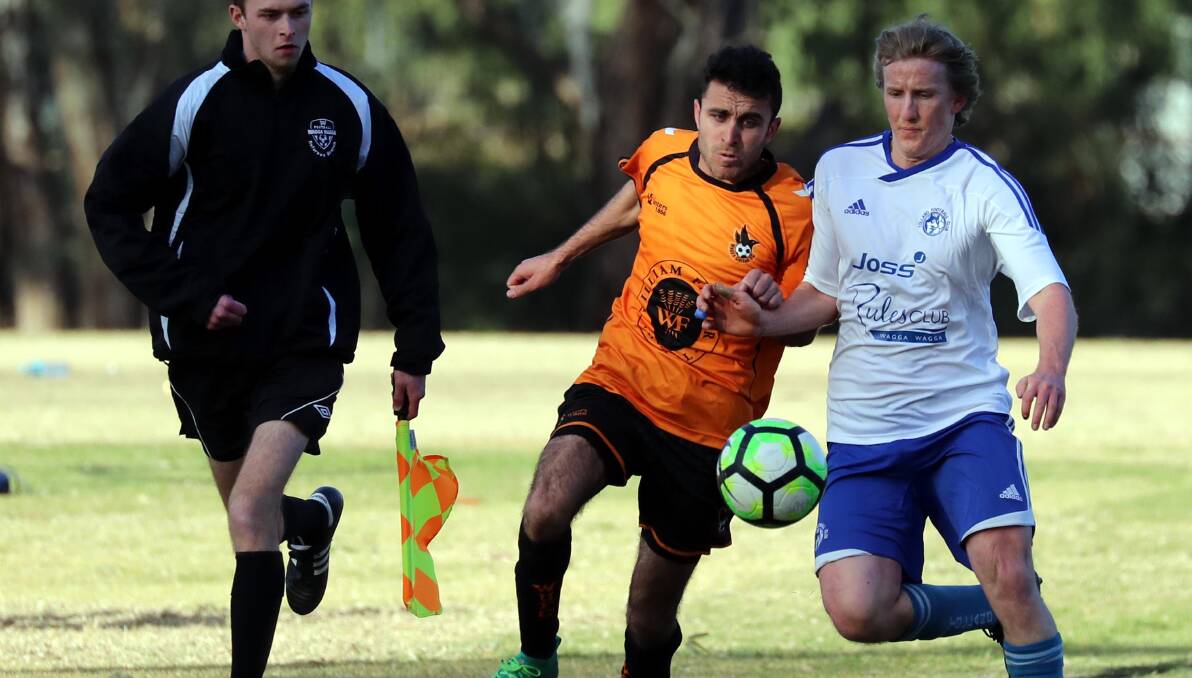 TOEING THE LINE: Nazar Yousif and Matthew Kleine get perilously close to the sideline during Wagga United's 3-0 win over Tolland at Rawlings Park on Sunday. Picture: Les Smith