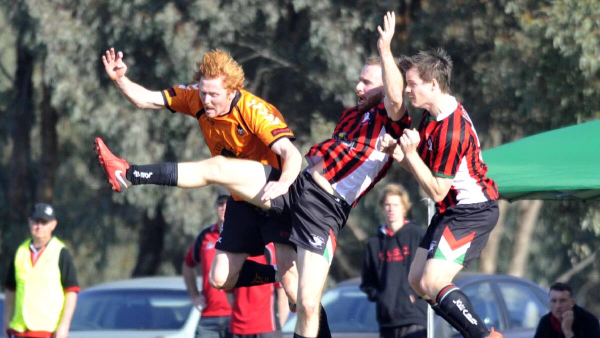 CONTEST: Rankin leaps between Wagga United's Tyler Allen and Lake Albert team mate Ben Matthews during their most recent encounter at Rawlings Park. 