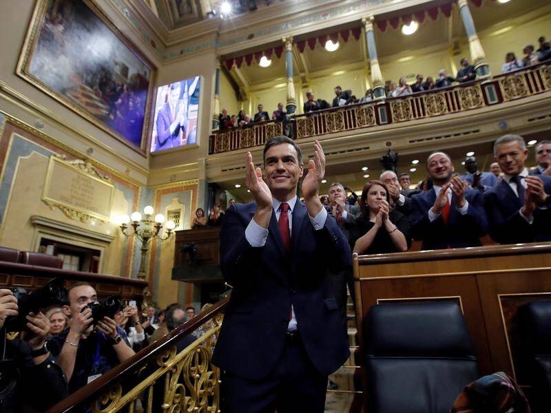 Spanish acting PM Pedro Sanchez takes the applause after winning the vote to form a new government.