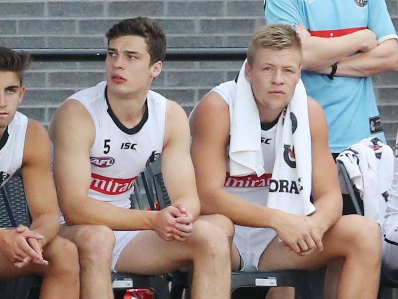 Jordan De Goey (right) on the bench for the Magpies during pre-season in February.