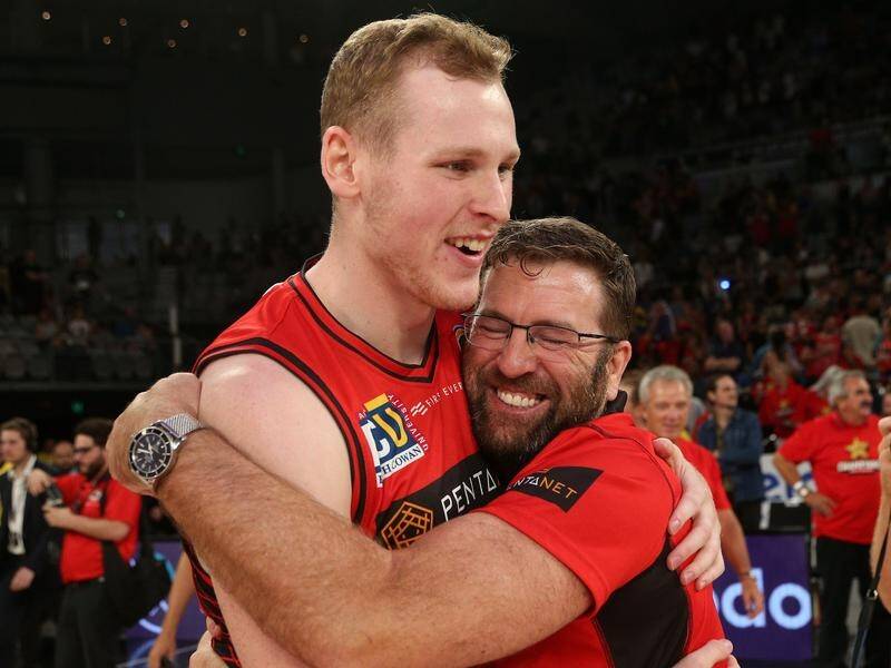 Rhys Vague of Perth (left) celebrates with coach Trevor Gleeson after the Wildcats' grand final win.