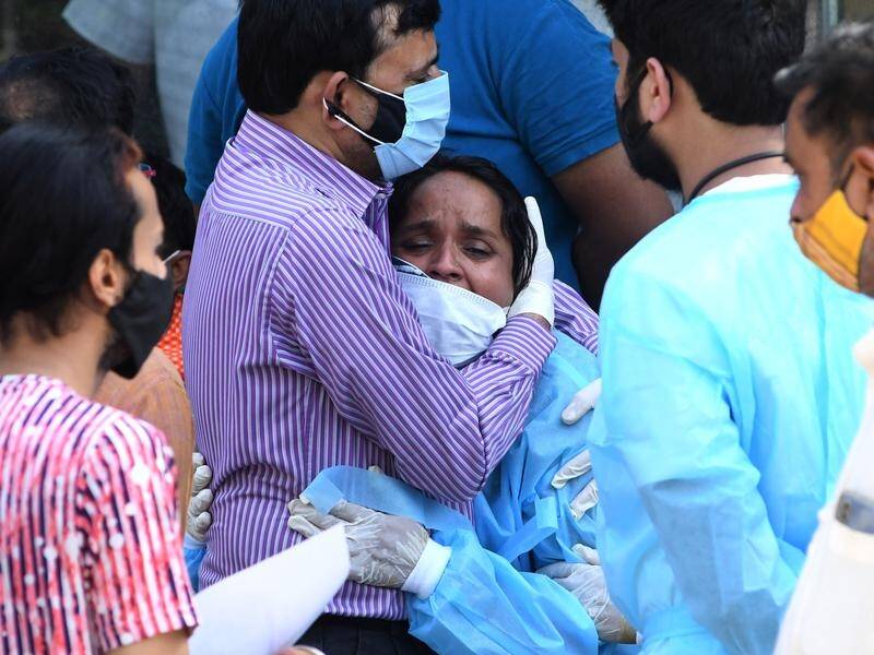Relatives mourn during the last rites of a COVID-19 victim at a crematorium in New Delhi.
