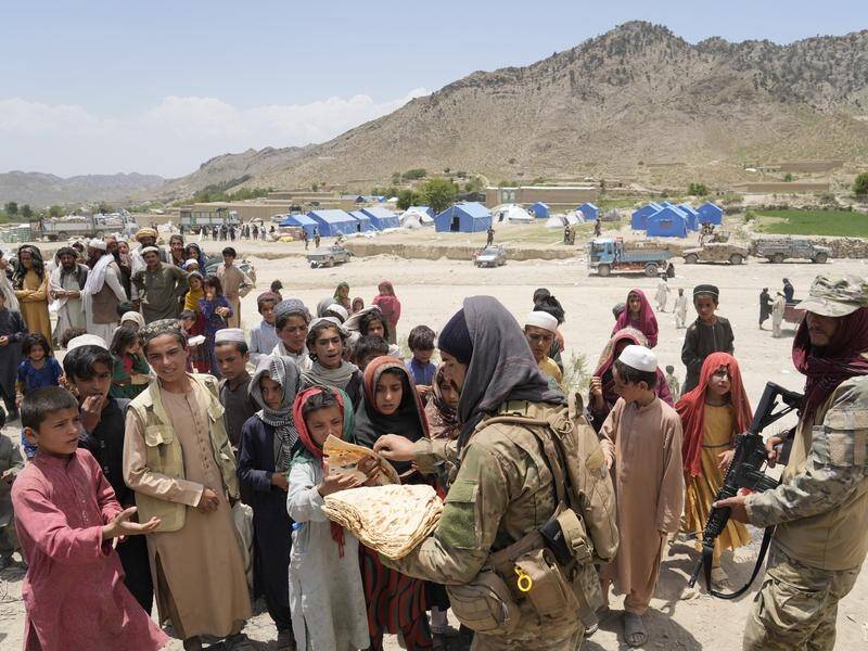 Afghans receive aid at a camp after a quake in Gayan district in Paktika province, Afghanistan.