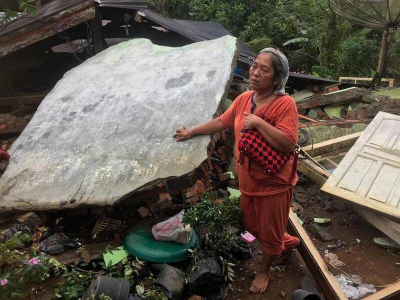 A woman stands in the ruins of her house after the earthquake in Sumatra which killed 10 people.