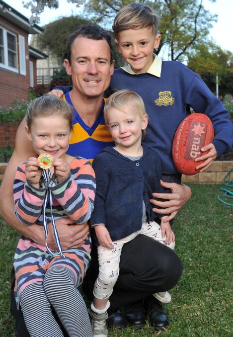 FAMILY AFFAIR: Mangoplah-Cookardinia United-Eastlakes coach Nathon Irvin prepares for Sunday's Riverina Football League grand final with children, Clover, 5, Tallow, 2, and Otis, 7. Picture: Michael Frogley