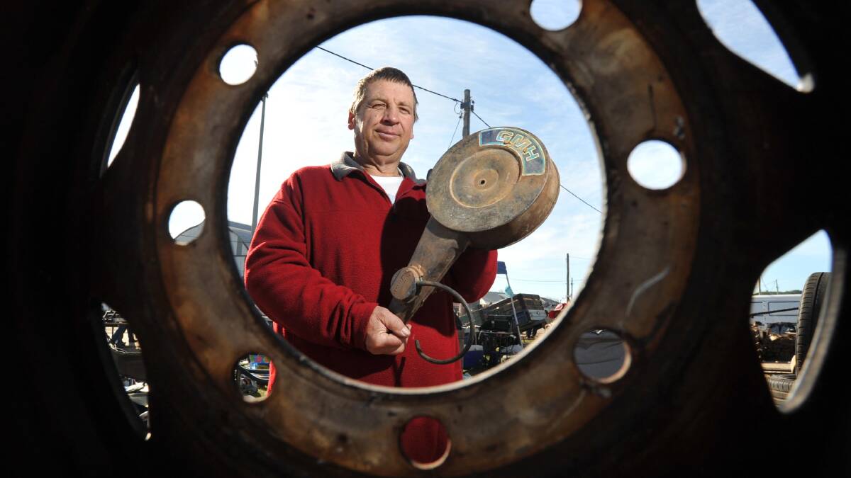 OLD TIN: Peter Angel, of Wagga, peers through a wheel arch at his store. Picture: Michael Frogley
