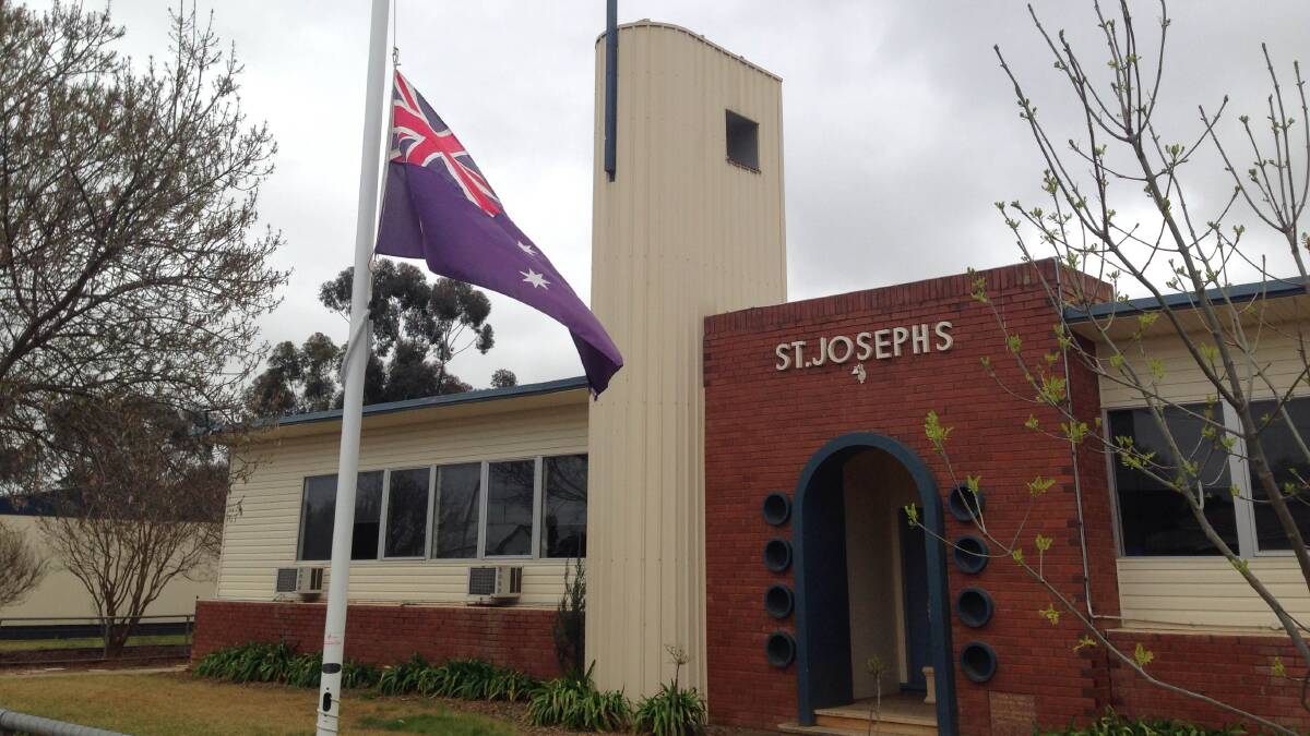 Flags at St Joseph's in Lockhart are lowered to half mast to remember Fletcher, Mia and Phoebe Hunt. Picture: Laura Hardwick
