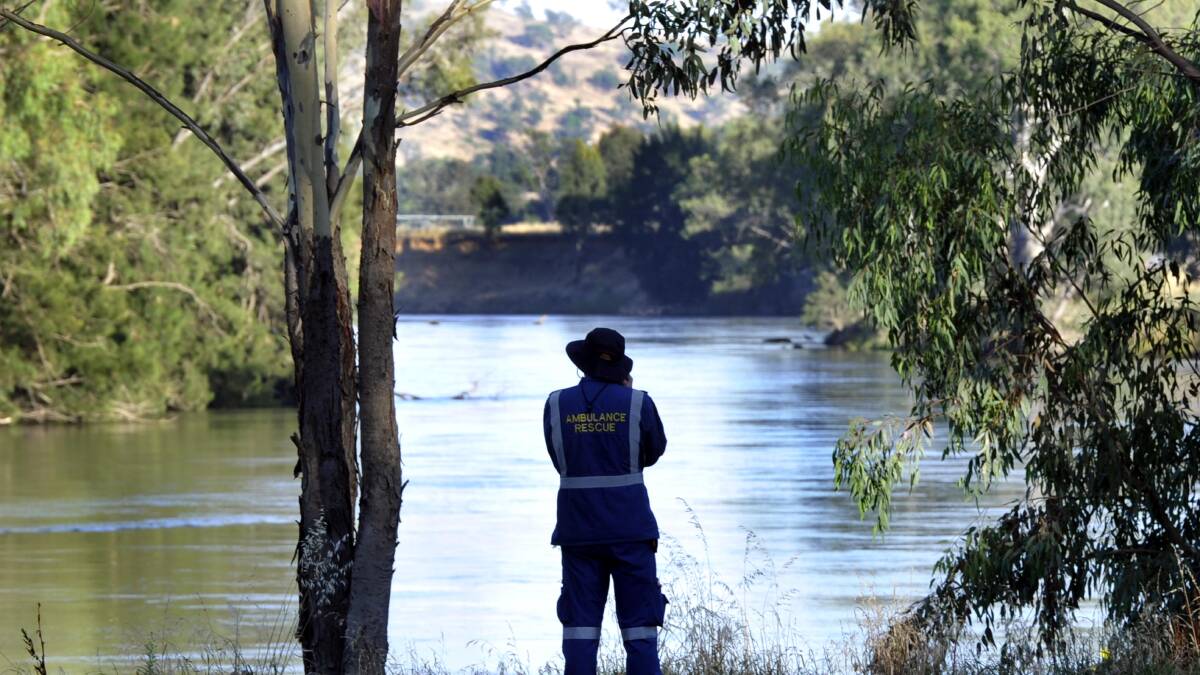 MISSING: An ambulance rescue officer casts his eyes across the stretch of Murrumbidgee River at Oura where a search has resumed for a man who went missing on Christmas Day.