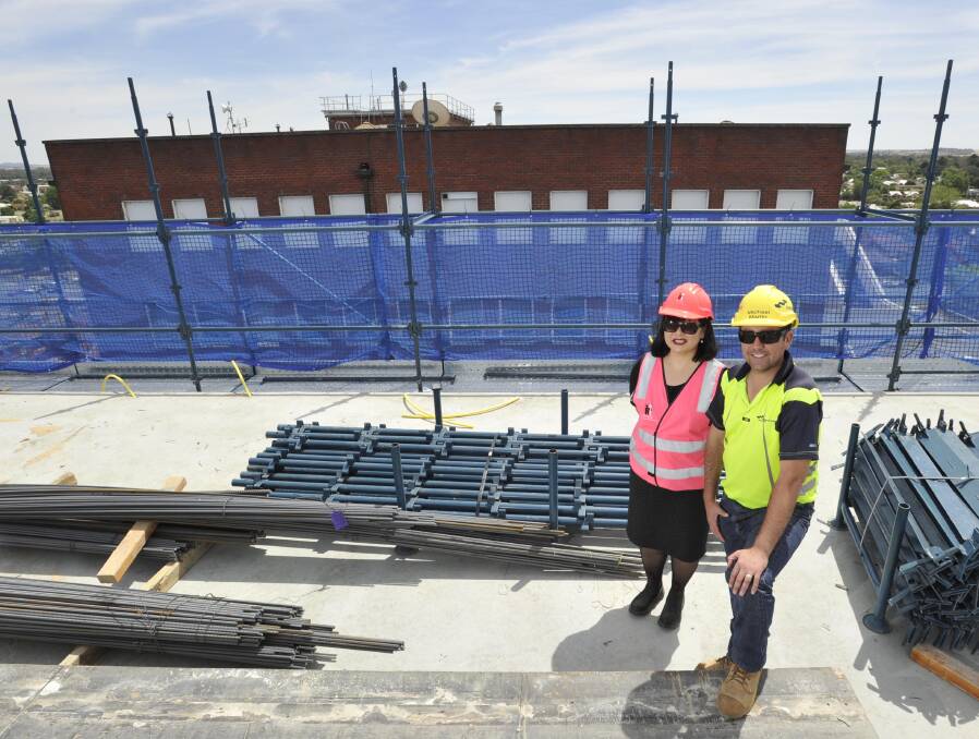 HIGH AND MIGHTY: Wagga Base Hospital redevelopment executive manager Irene Hing and Hansen Yuncken project manager Michael Martin on top of the new acute services building. In the background is the old hospital. Picture: Les Smith