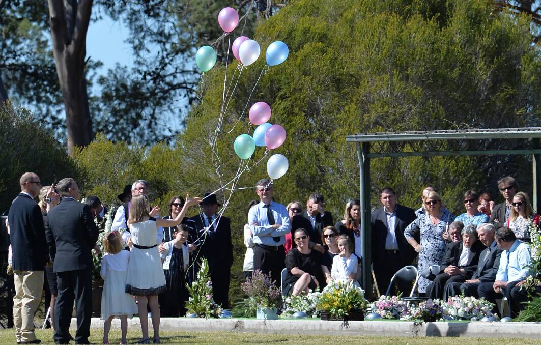 Ten balloons - pink, white, green and blue - are released at the conclusion of the Hunt family funeral at the Lockhart Cemetery on Tuesday. Picture: Michael Frogley